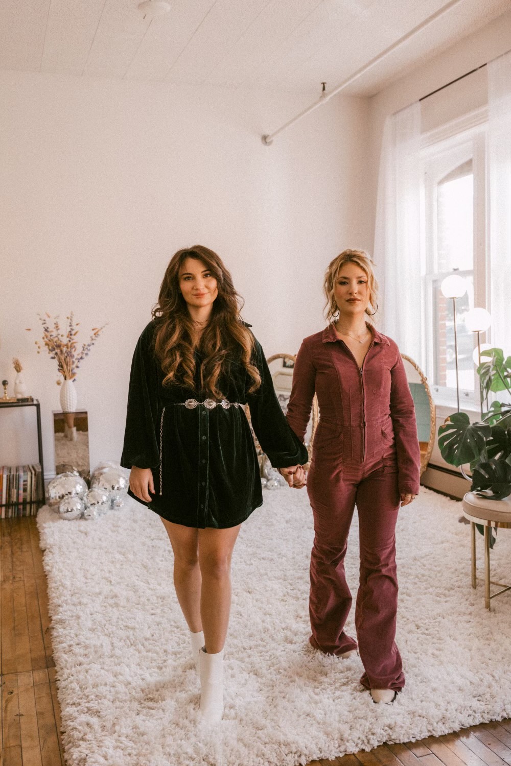 Two girls holding hands walking toward the camera
